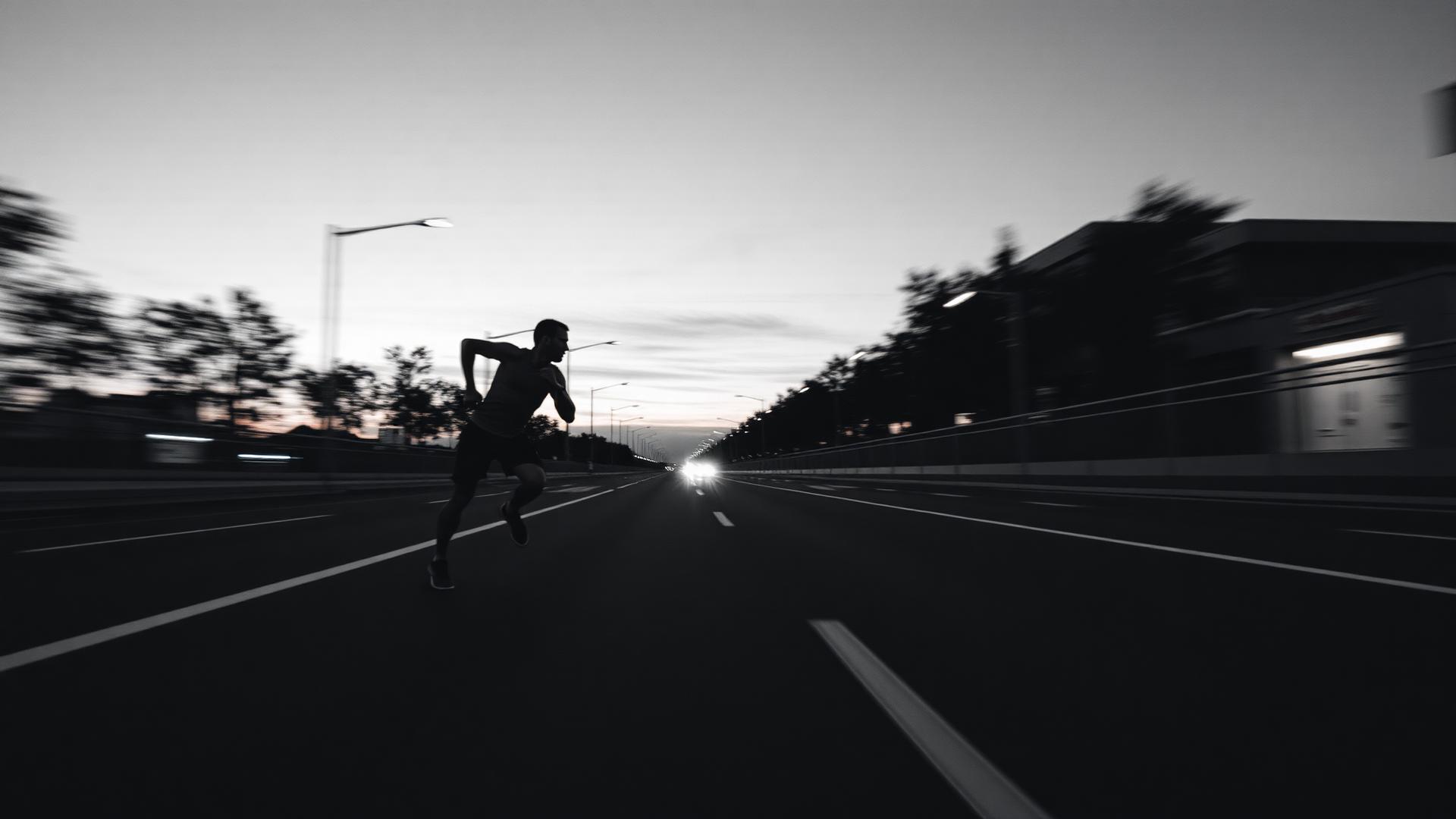 Athlete sprinting on empty road at dusk
